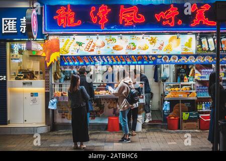 Hongkong, Hong Kong - Novembre 2019: Les gens achètent des aliments dans la rue la nuit à HongKong City, Tsim Sha Tsui Banque D'Images