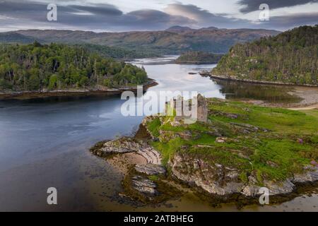 Tir aérien de drone du château de Tioram, c'est un château ruiné qui se trouve sur l'île marémotrice d'Eiléan Tioram au Loch Moidart, Lochaber, Highland, Ecosse. I Banque D'Images