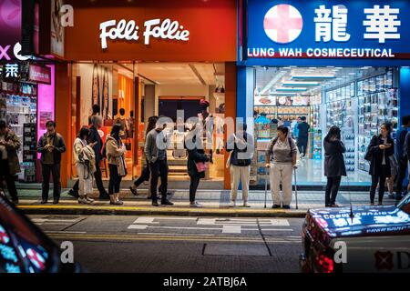 Hongkong, Hong Kong - Novembre 2019: Les gens dans la rue la nuit attendant le bus à HongKong City, Tsim Sha Tsui Banque D'Images