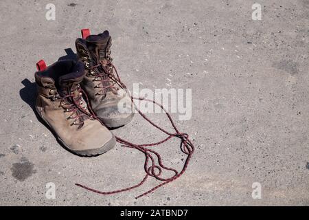 Paire de chaussures de randonnée préférées, portées et sales à haute altitude couvertes de boue et de lacets, vue de dessus. Concept voyage, randonnée pédestre, marche dans les montagnes Banque D'Images