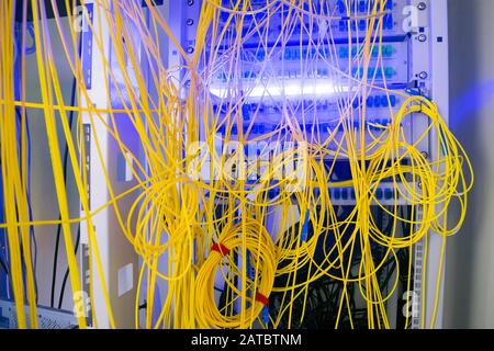 Le cadre de distribution fibre optique est situé dans la salle du serveur du centre de données. De nombreux câbles sont reliés dans le rack du serveur. Câble chaotique l Banque D'Images