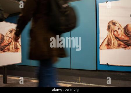 Belle fille publicité et une femme solitaire marche dans le couloir passager dans la station de métro de Berlin, Allemagne. Banque D'Images