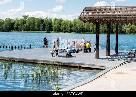 Kessel-Lo, Flandre Leuven / Belgique - 06 16 2019: Personnes assis sur le front d'eau sur une jetée en bois du lac du domaine provincial Kessel-Lo Banque D'Images