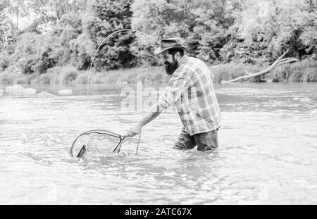 Zone de pêche. pêcheur avec canne à pêche pêcheur barbu. dans l'eau. week-end d'été. La pêche au gros. mature man fly fishing. man la capture de poissons. passe-temps et les activités sportives. pothunter. Banque D'Images