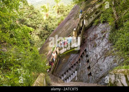 Mulkirigala, Sri Lanka - 4 novembre 2017: Les touristes descendent les escaliers de l'ancien temple bouddhiste de rock. Marches anciennes sculptées dans la roche, en t Banque D'Images