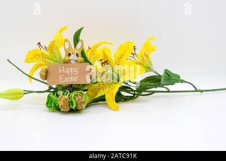 Joyeuses Pâques écrites sur un signe, tenu par un lapin avec une fleur isolée sur fond blanc Banque D'Images