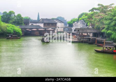 Wuzhen, Chine. 29 Août 2015. Des bateaux touristiques sur un petit lac dans la ville aquatique de Wuzhen, une journée bien remplie dans la province de Zhejiang en Chine. Banque D'Images