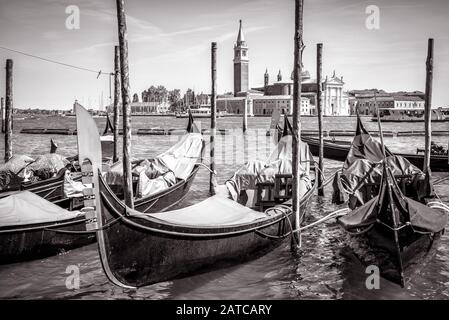 Gondoles dans le parking près de la place San Marco, Venise, Italie. La télécabine est un transport romantique à Venise. Vue traditionnelle de Venise en noir et blanc Banque D'Images