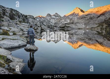 Homme debout sur un rocher regardant le mont Hooper Reflection à Rose Lake, Sierra National Forest, Californie, États-Unis Banque D'Images