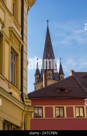 Sibiu, Roumanie, Juillet 2018. Le sommet de la cathédrale évangélique luthérienne s'élève au-dessus des bâtiments Banque D'Images