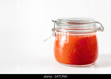 Sauce au piment chaud, pâte harissa. Adjika. Cuisine traditionnelle tunisienne, géorgienne et arabe. Harissa de rose maison dans un pot en verre. Banque D'Images