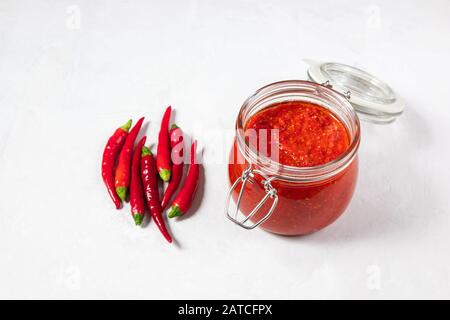 Sauce au piment chaud, pâte harissa. Adjika. Cuisine traditionnelle tunisienne, géorgienne et arabe. Harissa de rose maison dans un pot en verre. Espace de copie. Banque D'Images