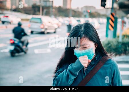 Femme malade avec le froid et la grippe marchant dans la rue Banque D'Images