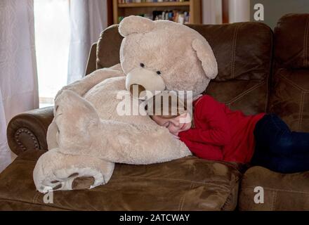 Petite fille prend une sieste sur le tour de son meilleur ami d'ours Banque D'Images