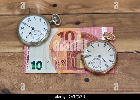 Photo grand angle de deux horloges vintage sur un dix Euro sur une table en bois Banque D'Images