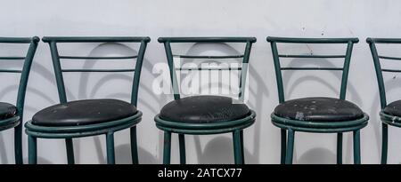 Photo panoramique de chaises vides placées dans une rangée près de le mur blanc Banque D'Images