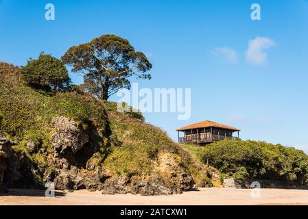 Belle vue sur une vieille maison près de la plage entourée par les arbres et l'herbe sous un ciel bleu Banque D'Images