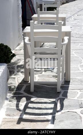 Vue verticale des tables et chaises confortables à l'extérieur d'une boutique Dans le village de Hora dans les Cyclades Banque D'Images