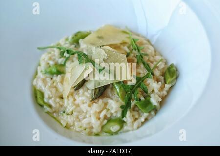 Risotto aux asperges avec roquette dans un plat blanc dans un restaurant étoilé au Michelin au Château de Bagnols Bagnols, France Banque D'Images