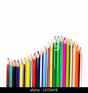 Crayons de bois colorés disposés en forme de vague sur un fond blanc Banque D'Images