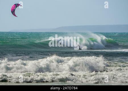 Un kitéboarder ou un paraborder navigue sur les vagues de cornish. ROYAUME-UNI Banque D'Images