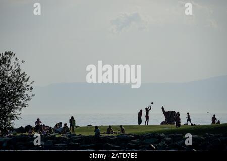 Un groupe de personnes jouent sur les rives du lac de Genève Banque D'Images