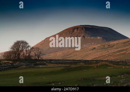 un spectaculaire sot à faible angle de Penyghent éclairé par le coucher du soleil de l'automne Banque D'Images