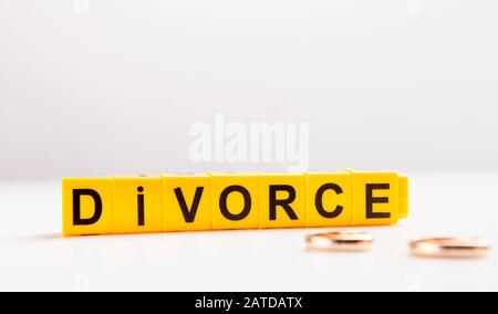 Lettres divorce et anneaux d'engagement sur la table blanche Banque D'Images