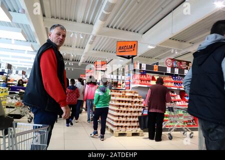 NIS, Serbie, Février 03,2019:entrée intérieure de Lidl, supermarché allemand de chaîne de réduction, homme regardant l'appareil photo et d'autres clients shopping allées Banque D'Images