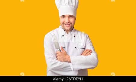 Couteau De Cuisine De Maintien De Chef Professionnel, Fond Jaune, Panorama Banque D'Images