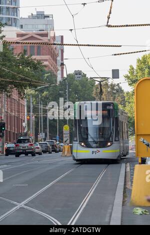 Un tramway moderne de Melbourne numéro 6048 sur une route de week-end en Australie. Voies de tramway visibles sur la route. Banque D'Images