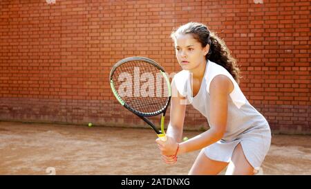 Gros plan portrait de jeune joueur de tennis féminin se concentrant et se concentrant sur son jeu Banque D'Images