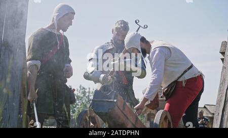 Chevaliers en offensive. Artilleryist tirer du canon. Reconstitution historique de la 14-15ème siècle, la Flandre. Banque D'Images