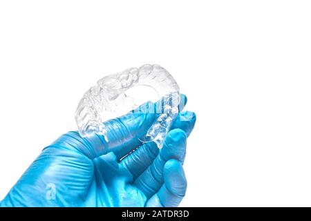 La main tient un jeu de plateaux dentaires personnalisés pour blanchir les dents. Isolé sur un fond blanc Banque D'Images