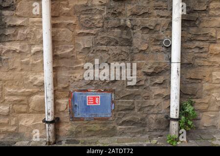 Mur de pierre avec deux drainpipes et panneau d'entrée de la rehausse sèche, Édimbourg, Écosse Banque D'Images