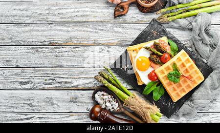 Petit Déjeuner. Gaufres belges avec œufs, asperges et bacon. Des aliments sains. Vue de dessus. Espace libre pour votre texte. Banque D'Images