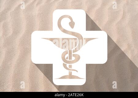 Icône de pharmacie dans une croix sur un fond de plage de sable Banque D'Images