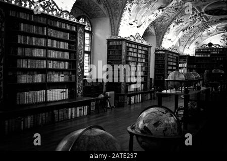 Prague, République tchèque - 30 décembre 2019: Ancienne bibliothèque avec globes et beaucoup de livres à l'intérieur des étagères décorées (salle théologique, bibliothèque Strahov) Banque D'Images