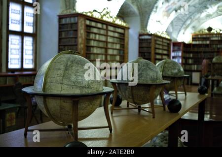 Prague, République tchèque - 30 décembre 2019: Ancienne bibliothèque avec globes et beaucoup de livres à l'intérieur des étagères décorées (salle théologique, bibliothèque Strahov) Banque D'Images