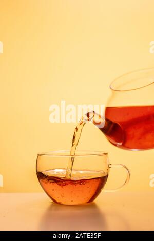 Thé servi dans une tasse de thé en verre sur fond de corail Banque D'Images