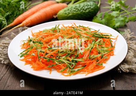 Salade de légumes avec carotte et concombre sur plaque blanche Banque D'Images