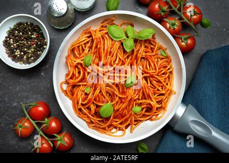 Gros plan de spaghetti avec suace de tomate dans une casserole sur fond noir Banque D'Images