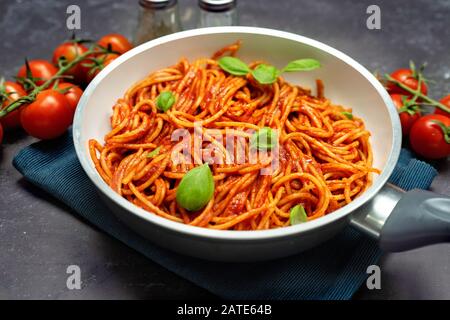 Gros plan de spaghetti avec suace de tomate dans une casserole sur fond noir Banque D'Images