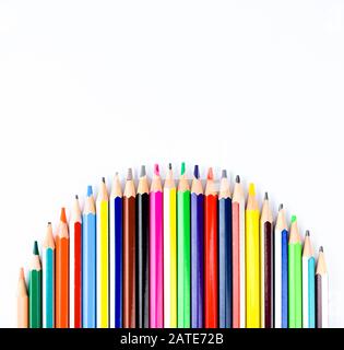 Crayon de couleur disposé dans une formation ondulée sur un fond blanc isolé Banque D'Images