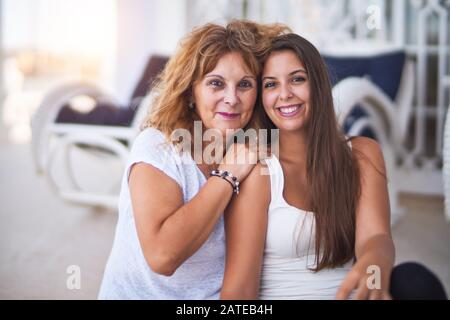 Belle Mère et fille assis à terrasse hugging and smiling Banque D'Images