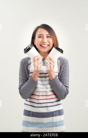 Gros plan photo magnifique sa femme serveuse propriétaire cafétéria tenir les mains bras en papier tasses boisson chaude inviter visite café porter tablier isolé W Banque D'Images
