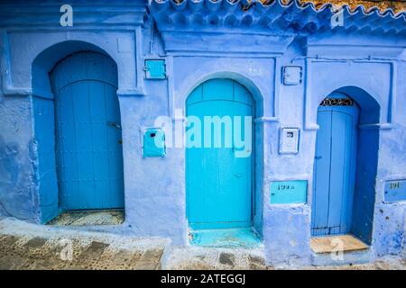 Porte bleue traditionnelle sur une ancienne rue à l'intérieur de Medina de Chefchaouen, Maroc Banque D'Images