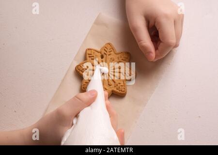 Un garçon de 10 ans vire les cookies avec un sac culinaire. Fait Main. La créativité des enfants Banque D'Images