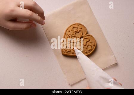 Un garçon de 10 ans vire les cookies avec un sac culinaire. Fait Main. La créativité des enfants Banque D'Images