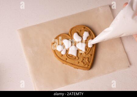 Un garçon de 10 ans vire les cookies avec un sac culinaire. Fait Main. La créativité des enfants Banque D'Images